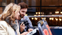 Couple looking a map on an open top bus