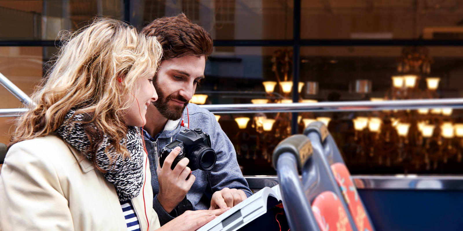 Couple looking a map on an open top bus