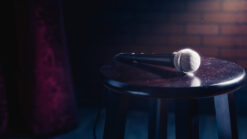 Microphone on a wooden stool on a stand up comedy stage