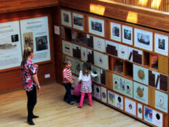 Mum and two children looking at Storytelling Wall