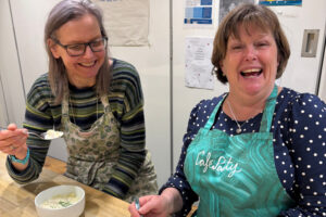 Two women enjoying a Scottish cookery class